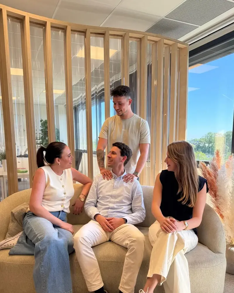 Vier collega’s in de zithoek op kantoor